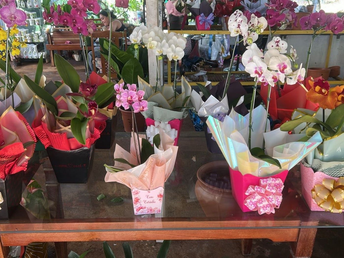 Orquídeas e buquês embalados no balcão da floricultura